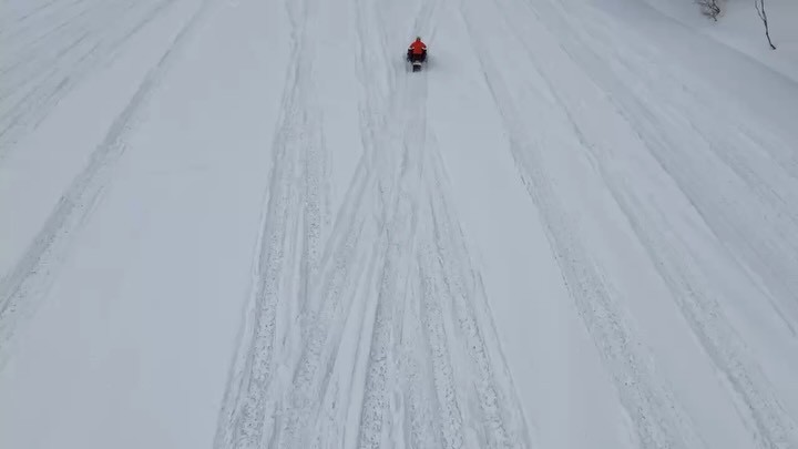 A lone snowmobile on the snowfield, seen from above